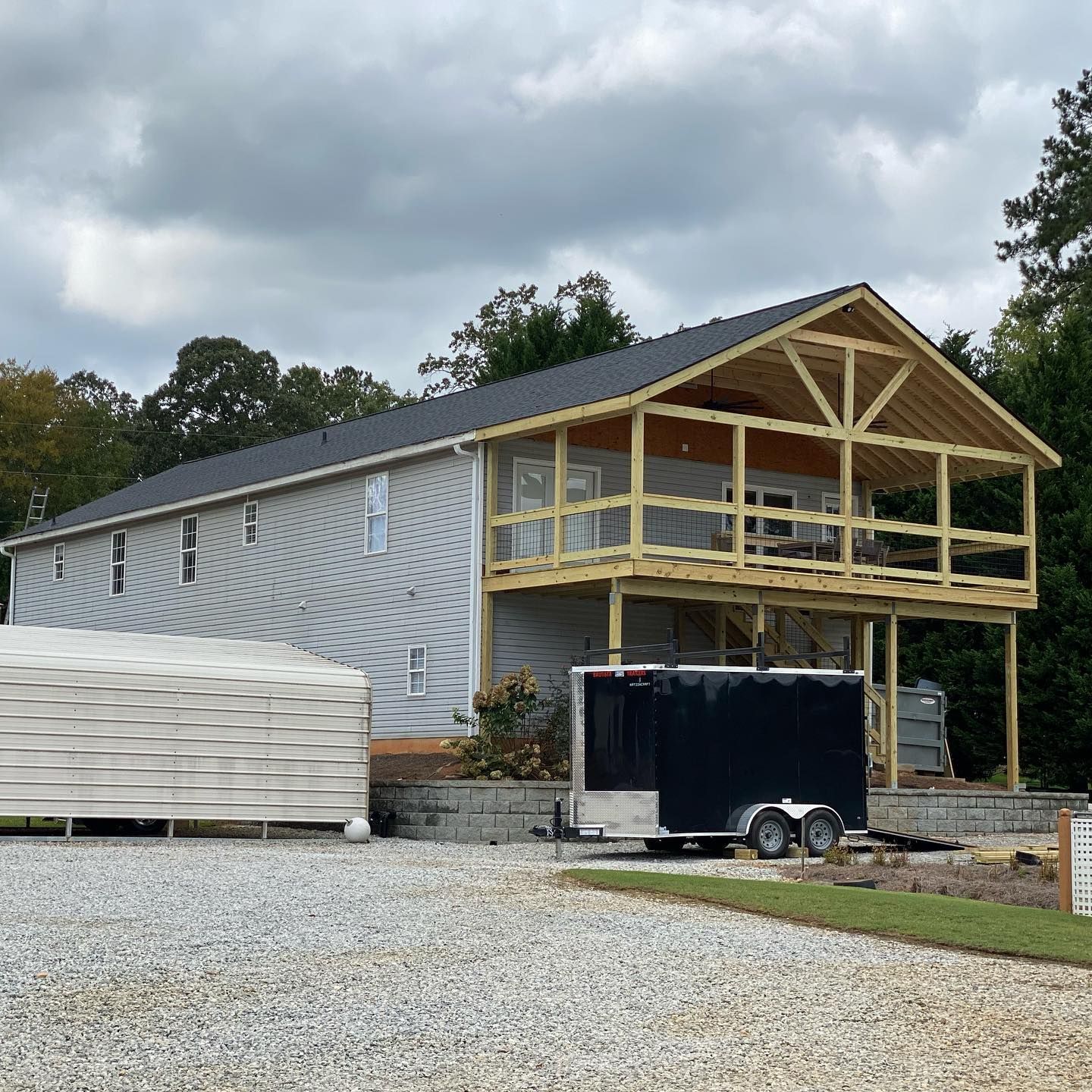 A house under construction with a trailer parked in front of it