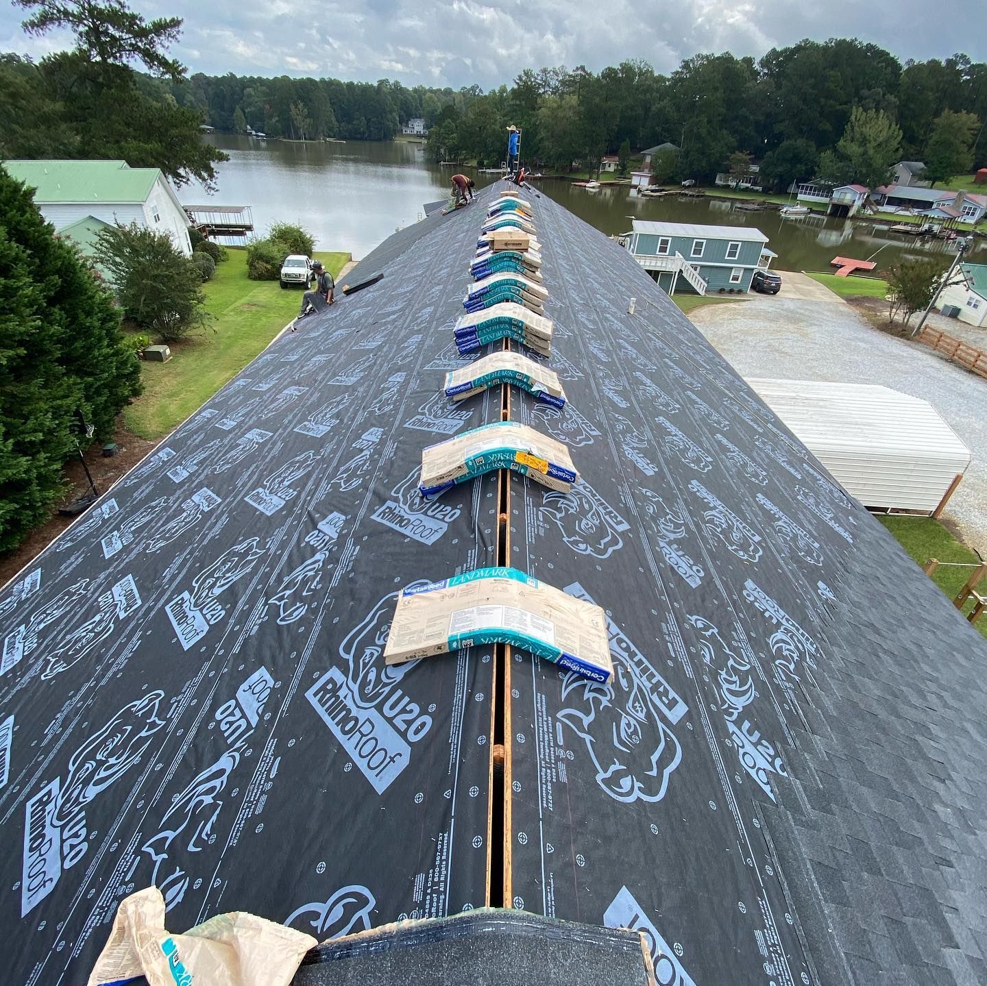 A roof with a lot of shingles on it and a lake in the background