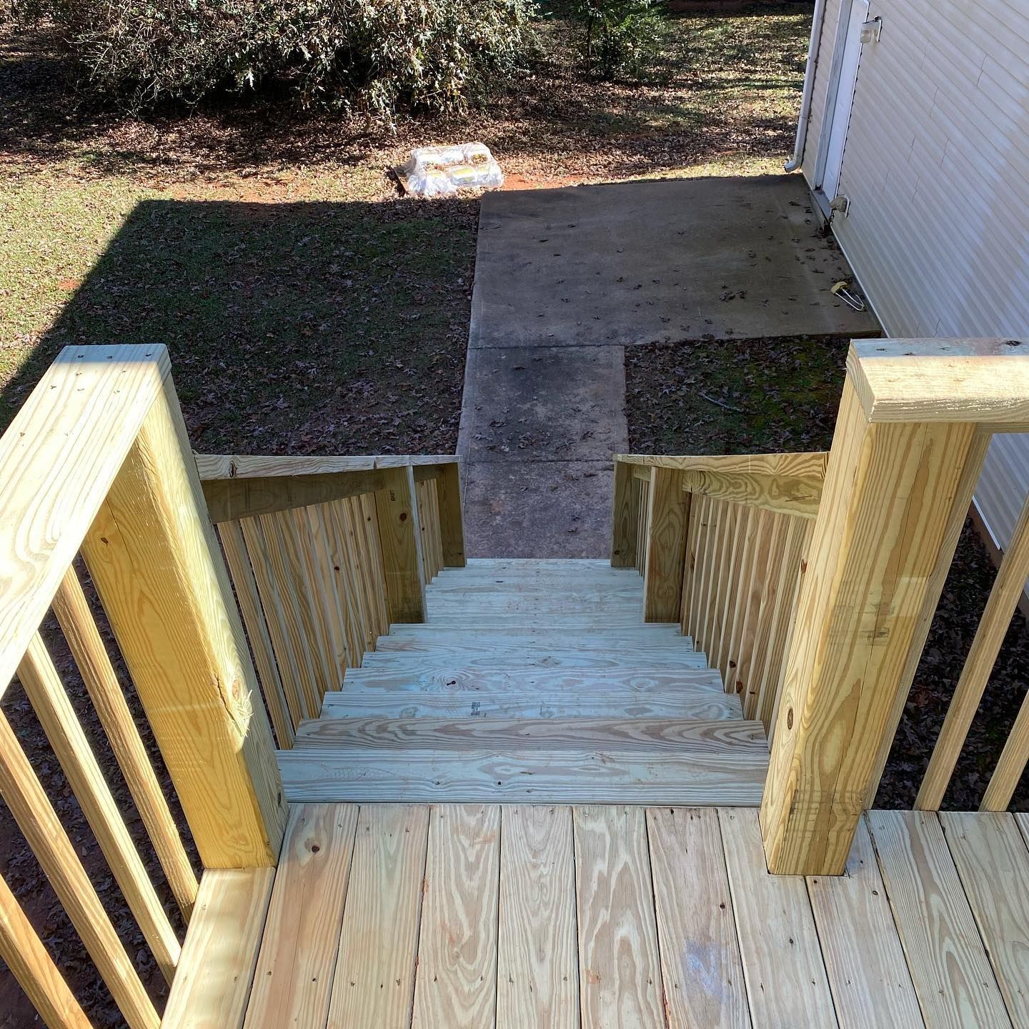 A wooden deck with stairs leading up to a house.