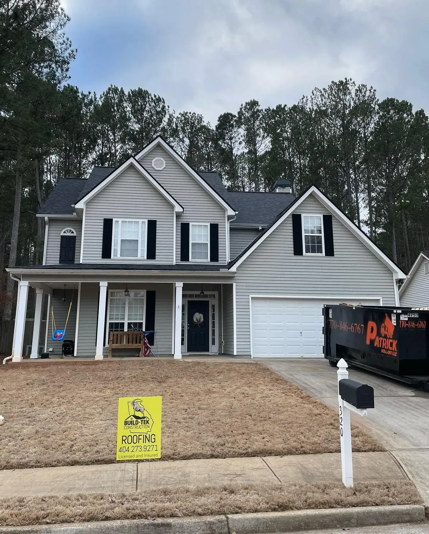 A large house with a dumpster in front of it.