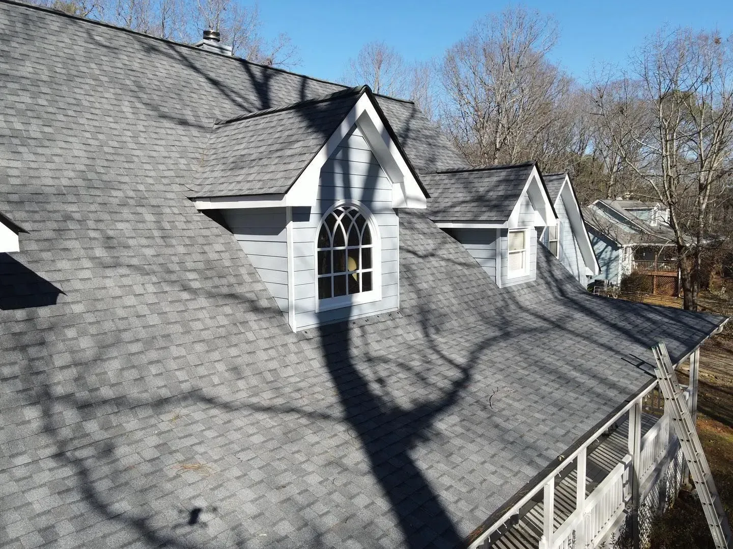 A house with a gray roof and a window on the roof.