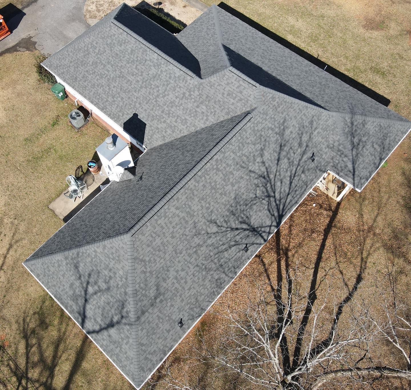 An aerial view of a house with a gray roof