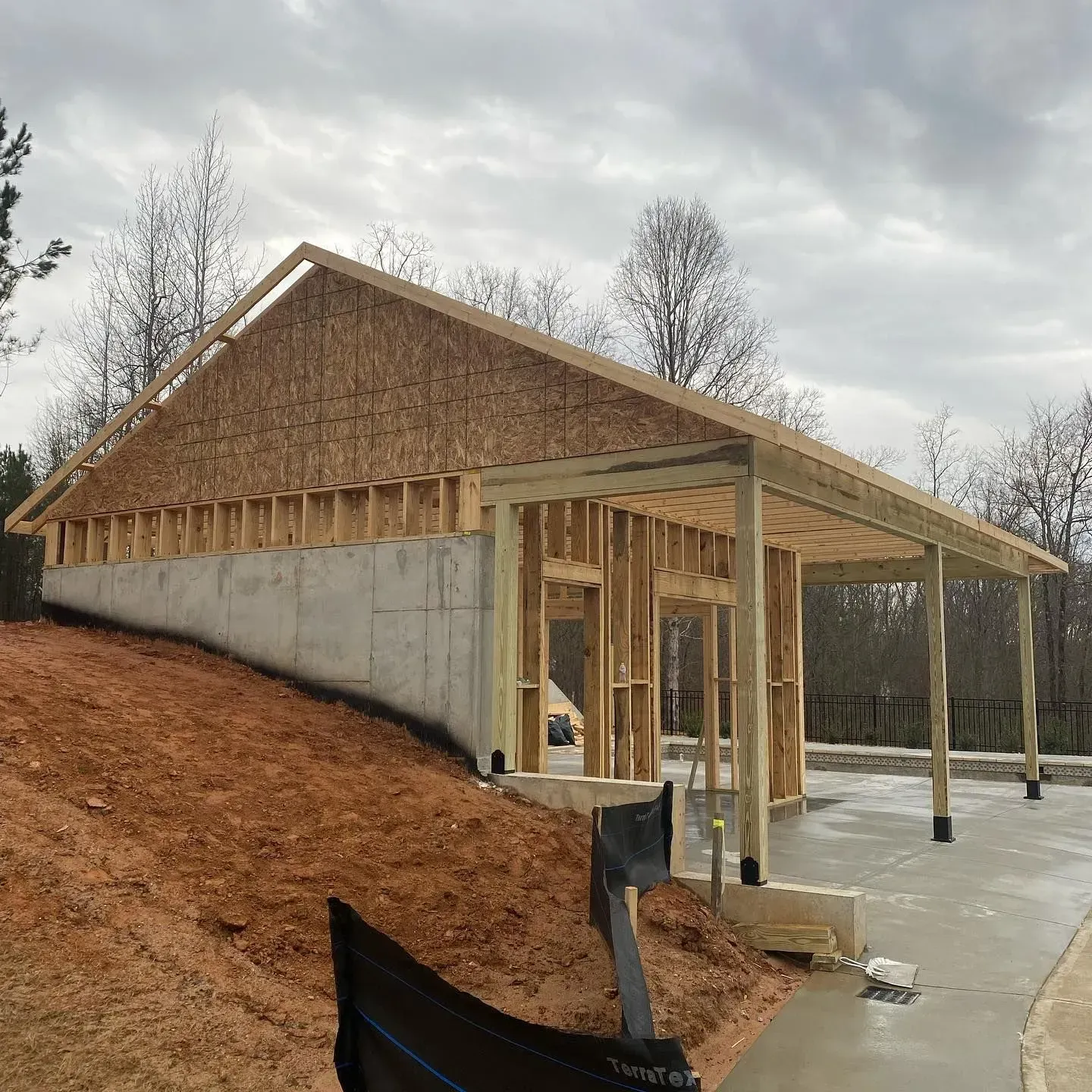 A house is being built on top of a dirt hill.