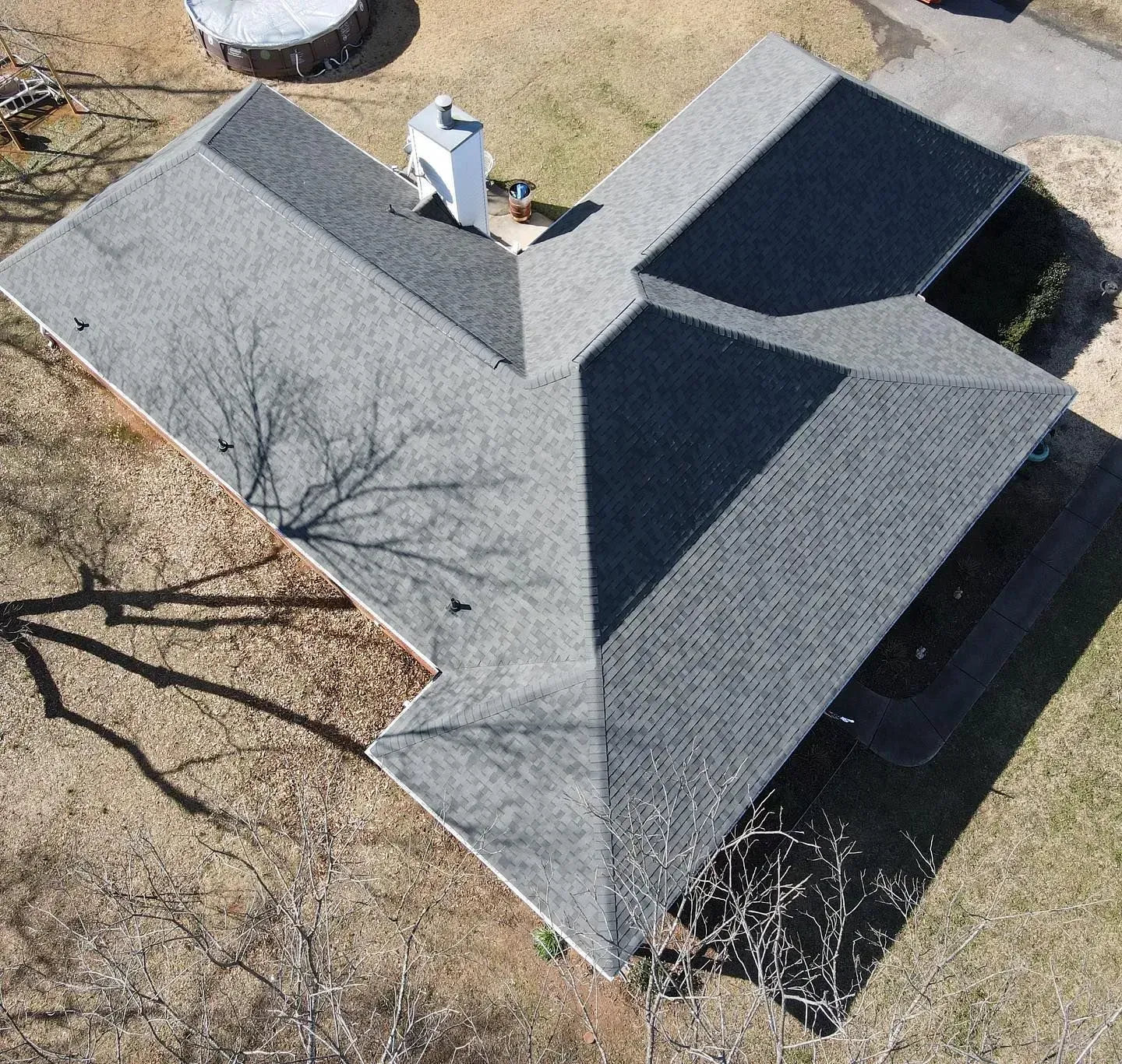 An aerial view of a house with a gray roof