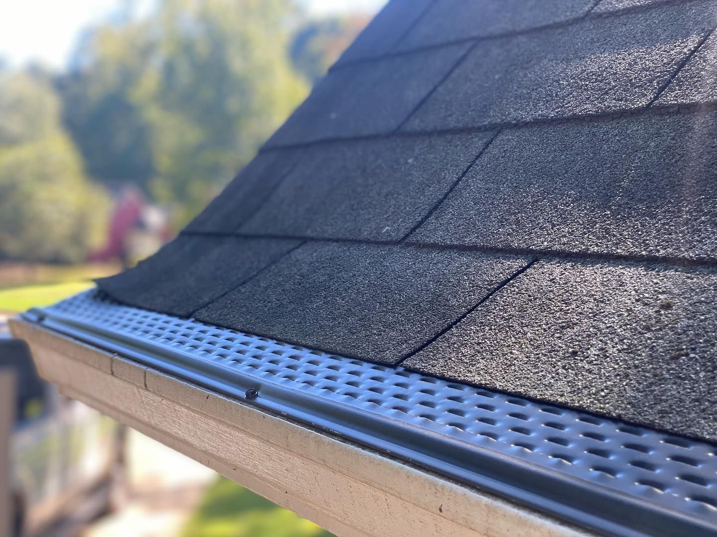 A close up of a roof with shingles and a gutter