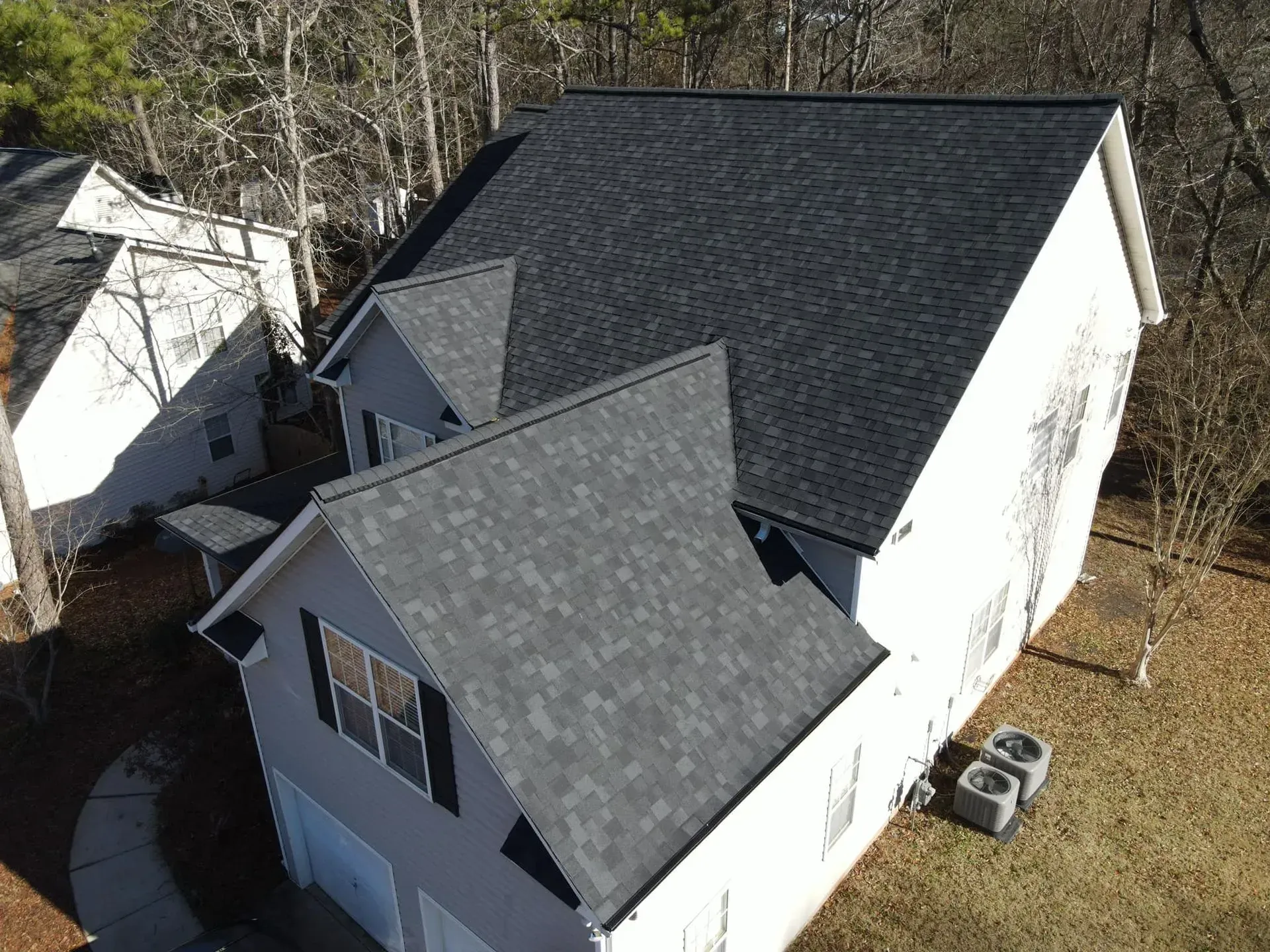 An aerial view of a house with a black roof.