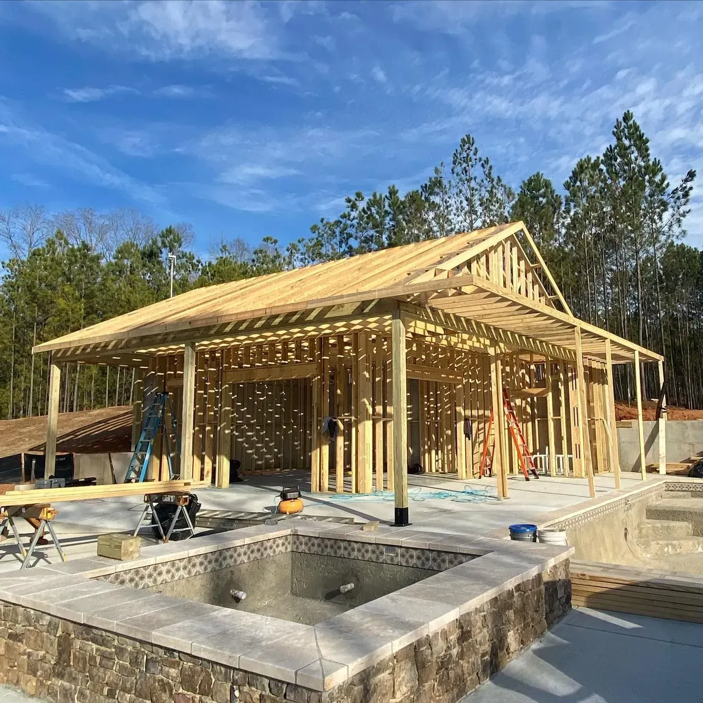 A house is being built with a pool in the backyard.