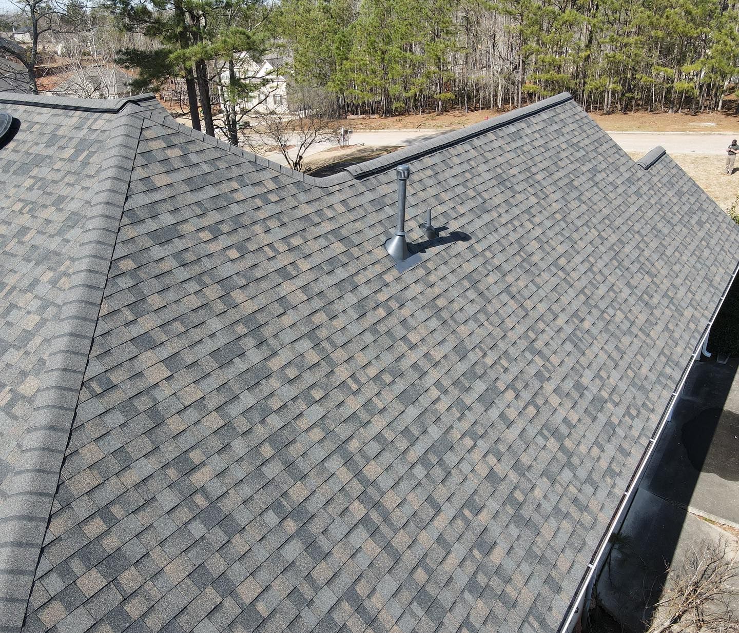 An aerial view of a roof with shingles and a chimney.