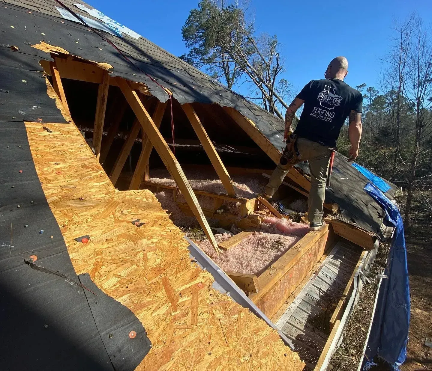 A man standing on top of a roof with a shirt that says ' freedom ' on it