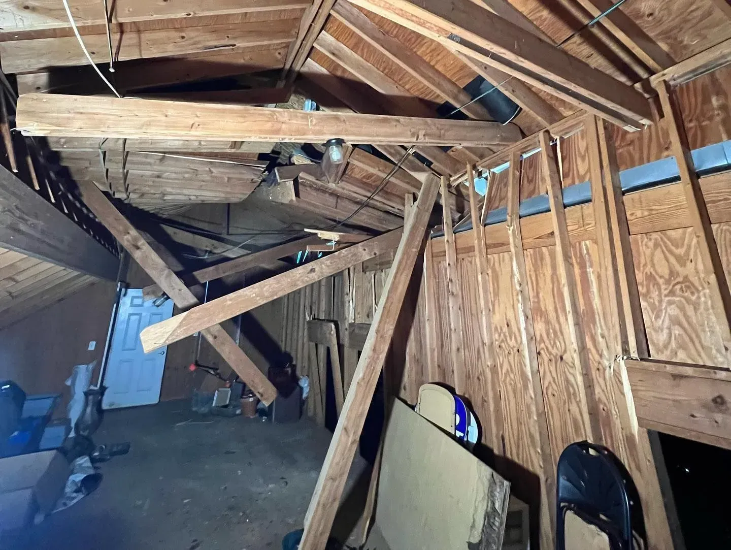 An attic with a lot of wooden beams and a ceiling.
