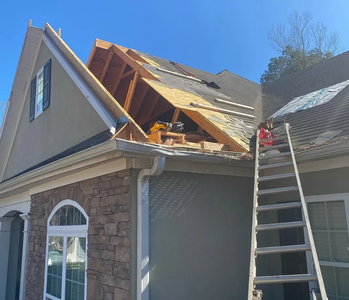 A ladder is sitting on the roof of a house.