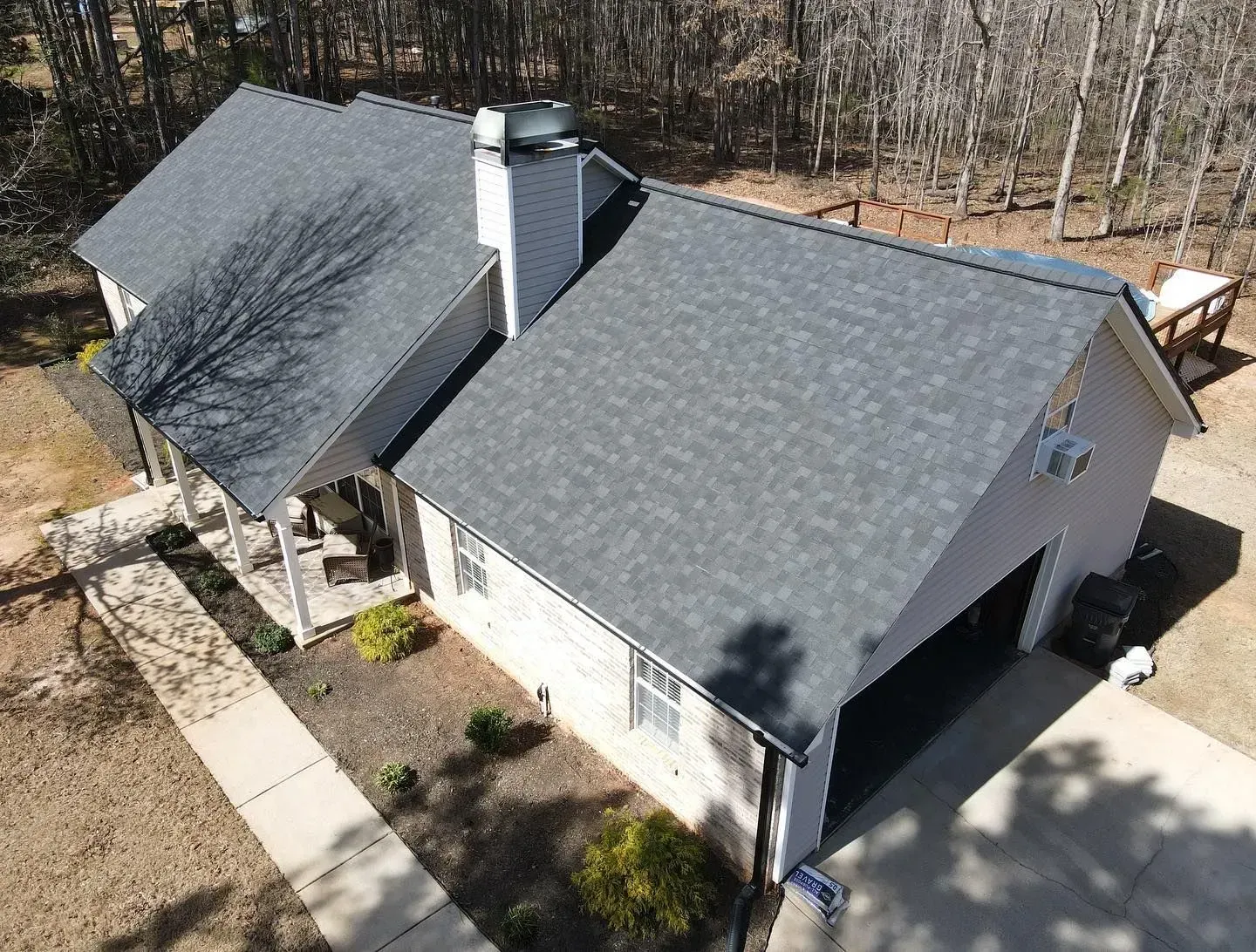 An aerial view of a house with a gray roof and a garage.