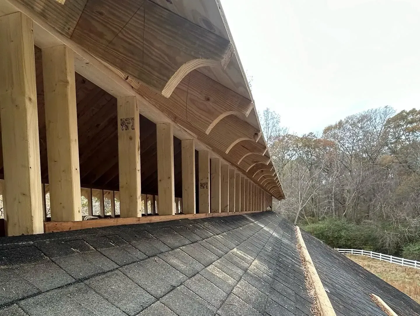 A roof is being built with wooden beams and shingles.