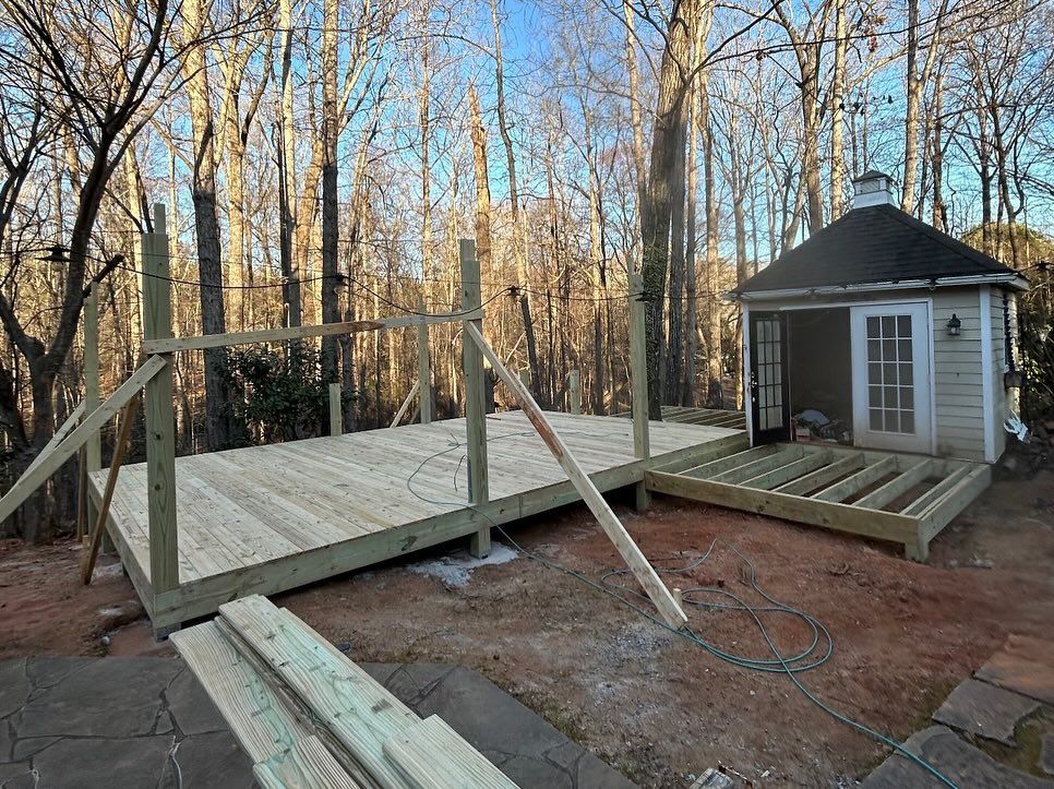 A wooden deck is being built in the backyard of a house.