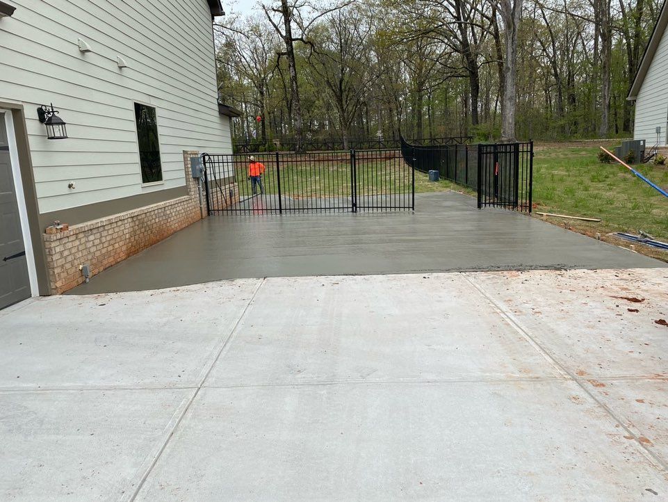 A concrete driveway is being built in front of a house.