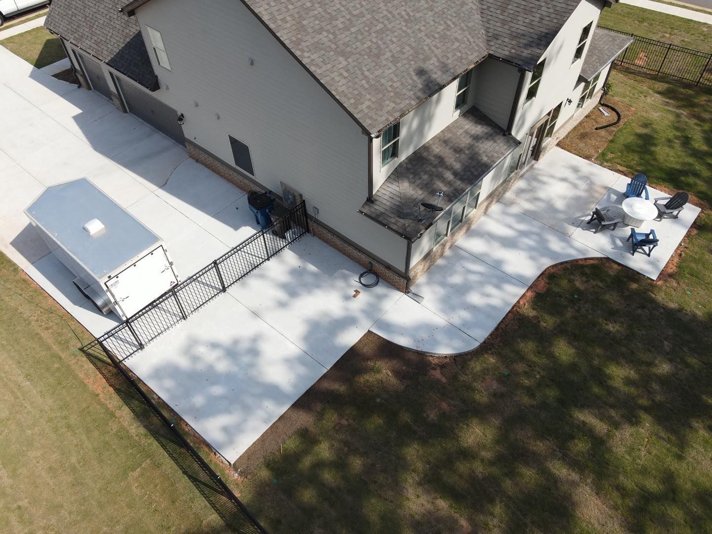 An aerial view of a house with a trailer parked in front of it.