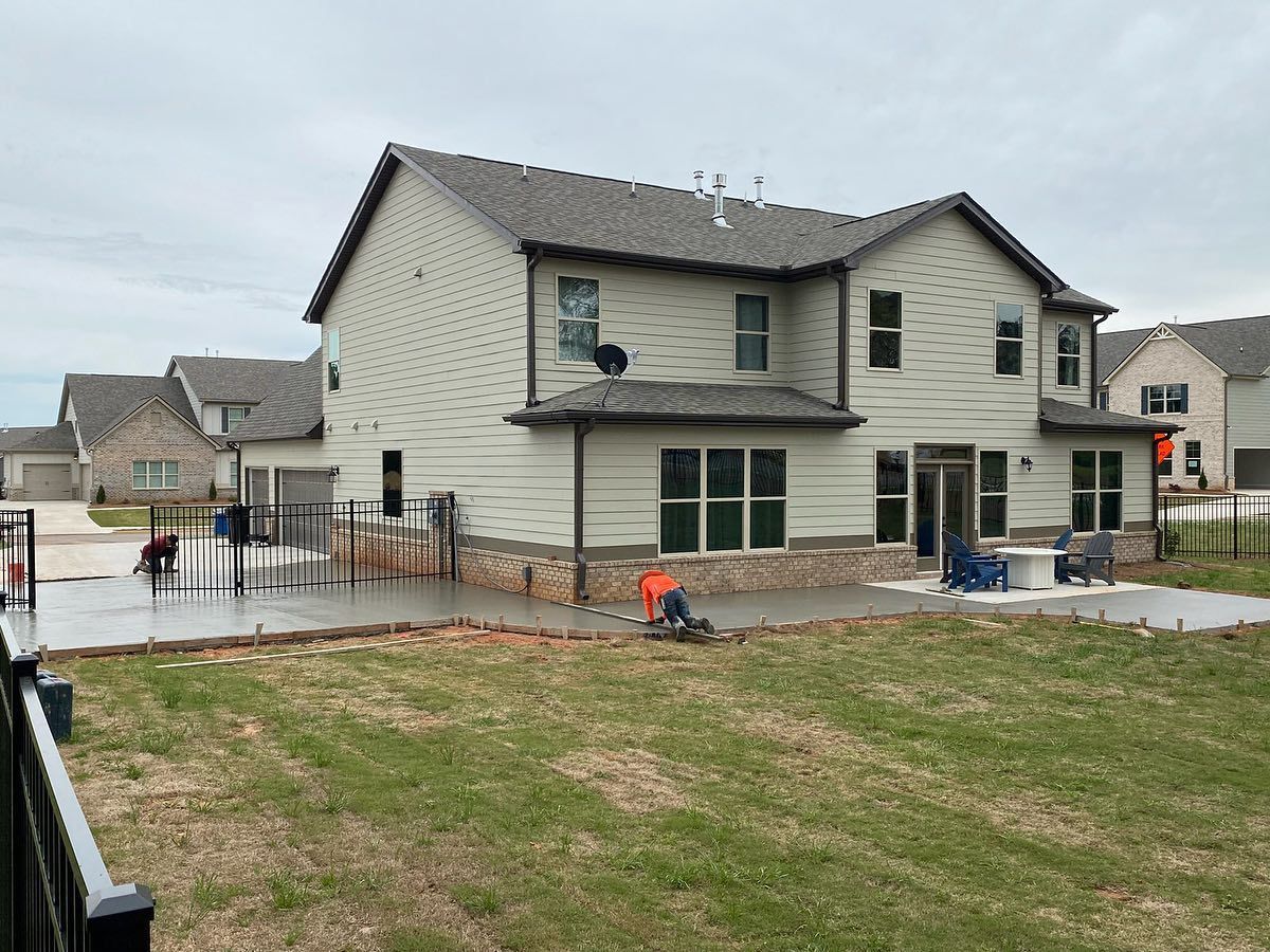 A large house with a fence and a patio in front of it.