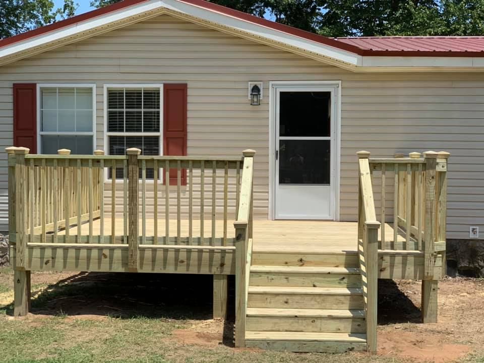 A mobile home with a wooden deck and stairs