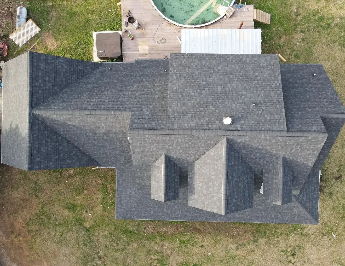 An aerial view of a house with a pool in the backyard.