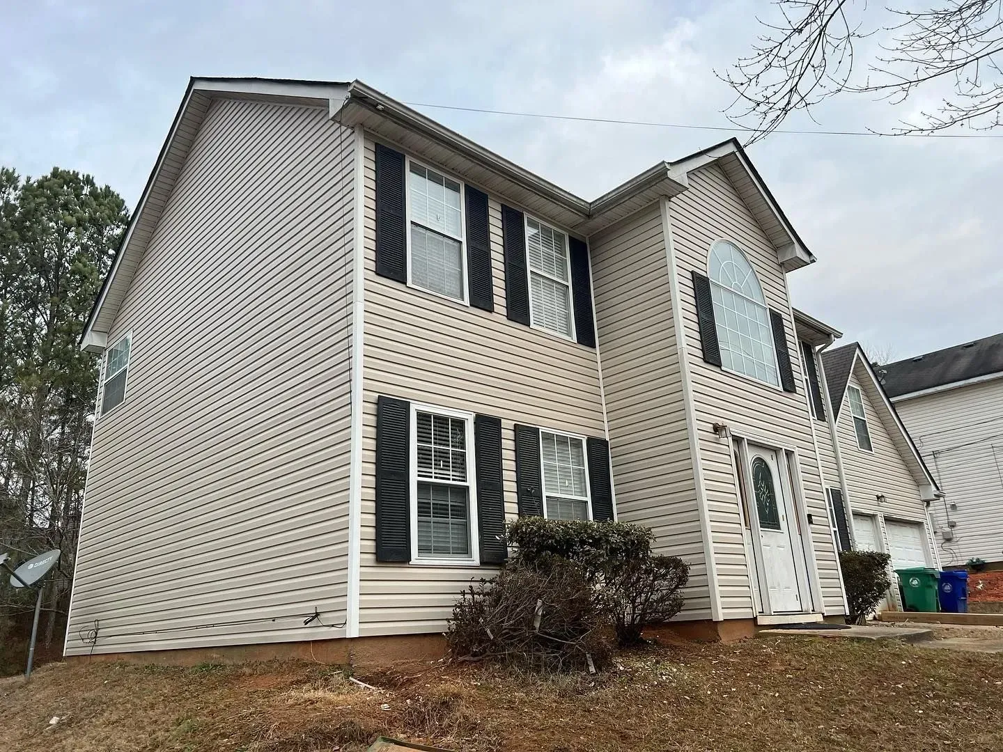 A large white house with black shutters on the windows.