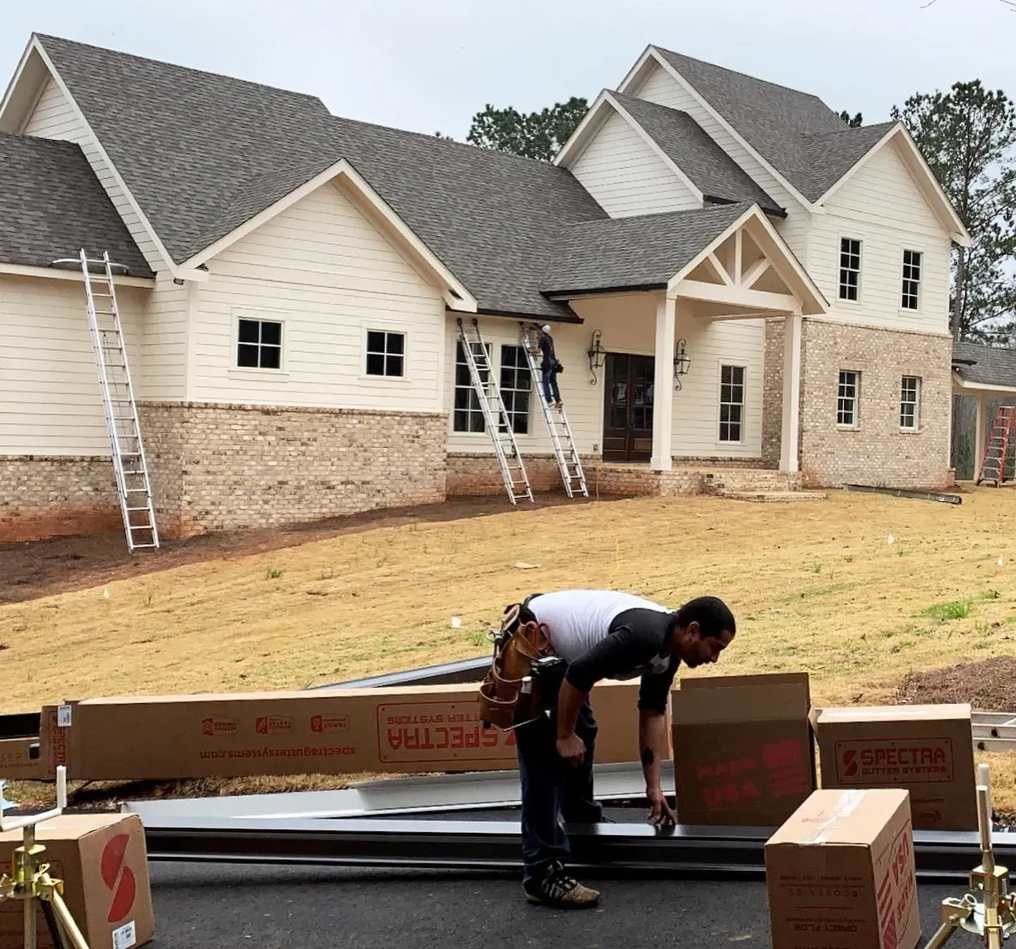 A man is working on a beam that says spectrum on it