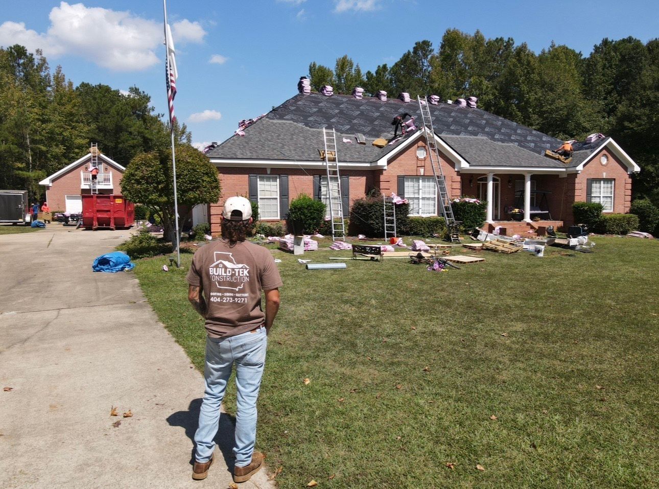 A man standing in front of a house that is being remodeled