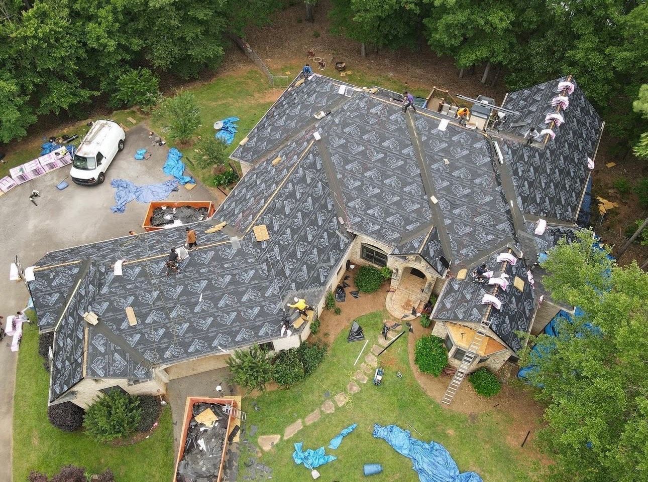 An aerial view of a house with a roof being installed.