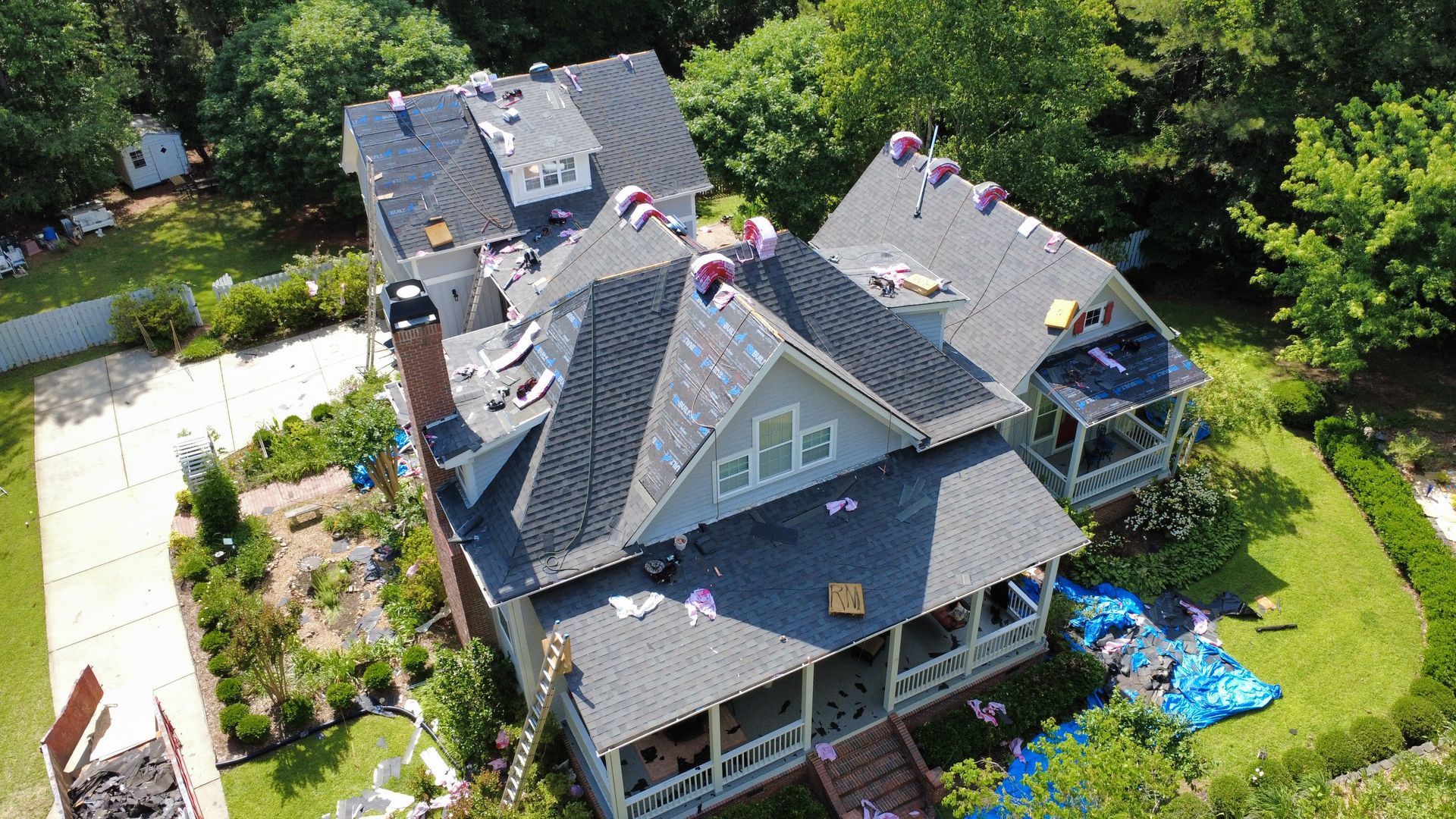 An aerial view of a large house with a roof being installed.