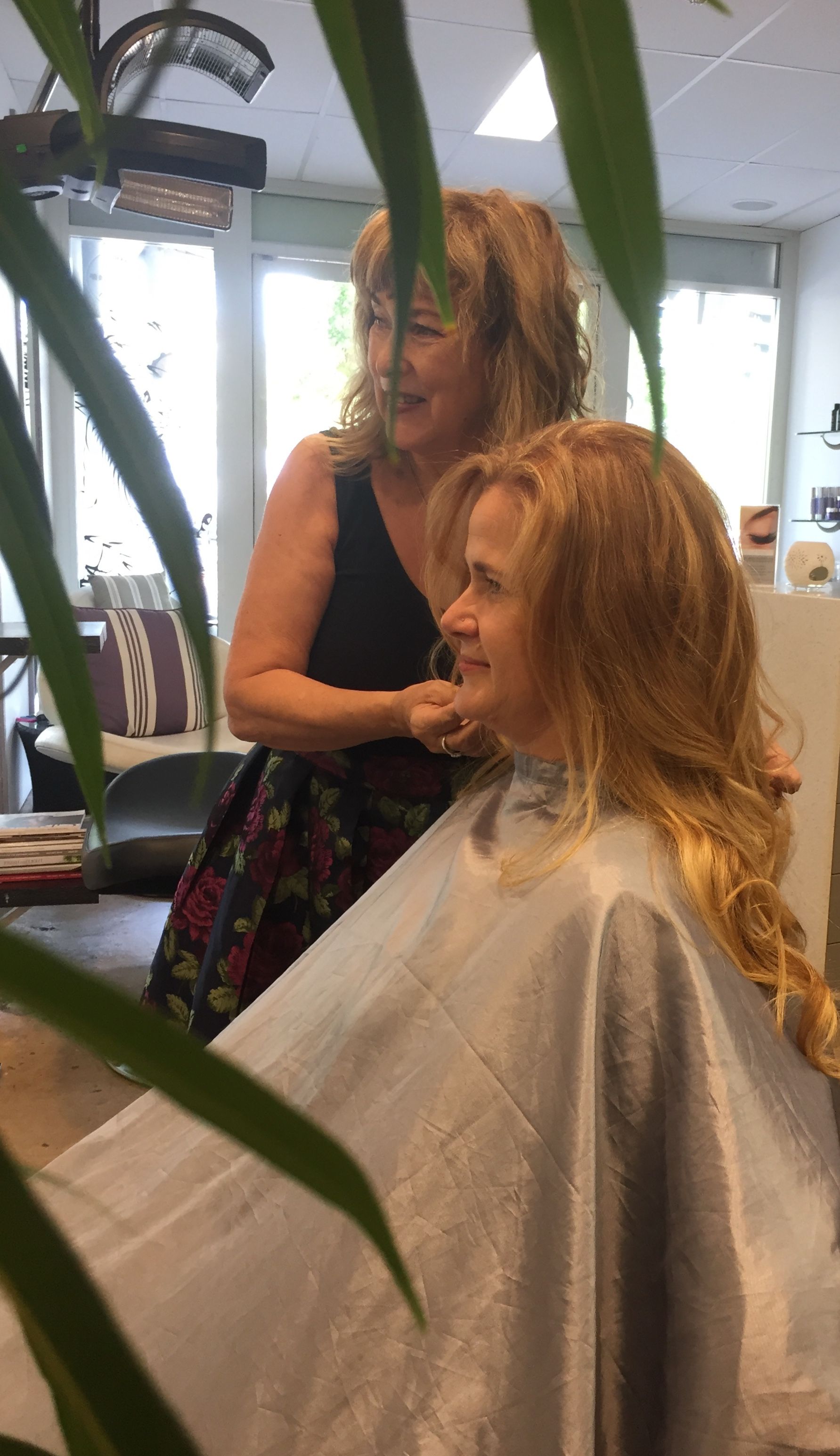 A Woman Is Getting Her Hair Cut By A Hairdresser In A Salon — Fuse Hair & Beauty In Darwin City, NT