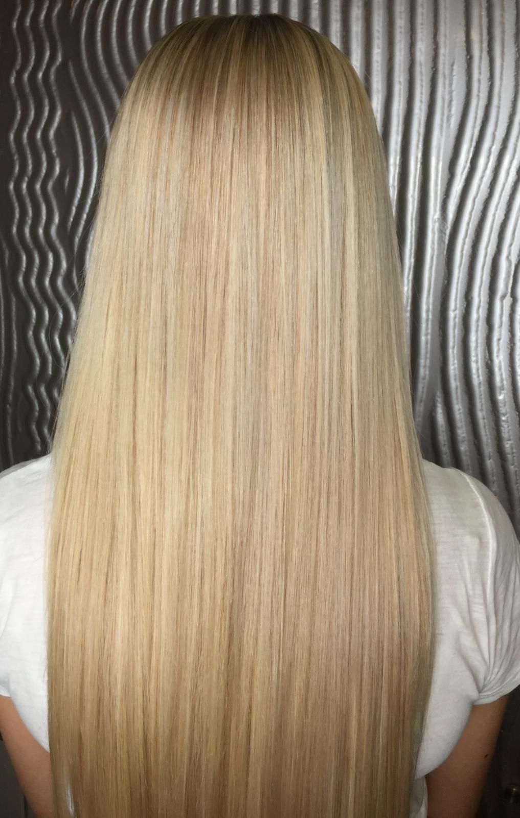 A Woman With Long Blonde Hair Is Wearing A White Shirt — Fuse Hair & Beauty In Darwin City, NT