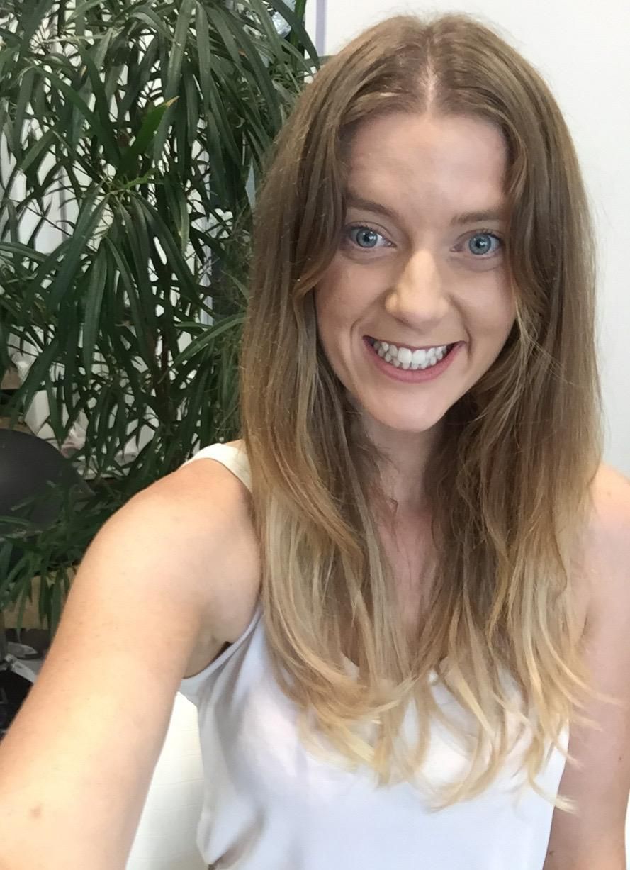 A Woman Is Smiling And Taking A Selfie In Front Of A Plant — Fuse Hair & Beauty In Darwin City, NT