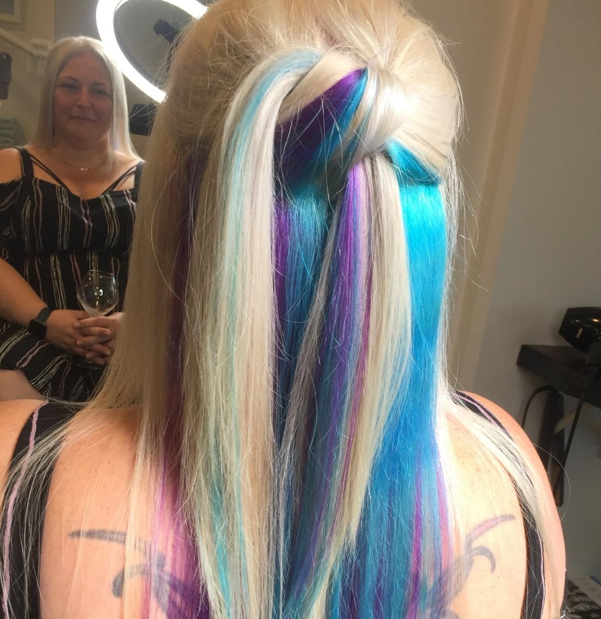 A Woman With Blue And Purple Hair Is Sitting In Front Of A Mirror — Fuse Hair & Beauty In Darwin City, NT