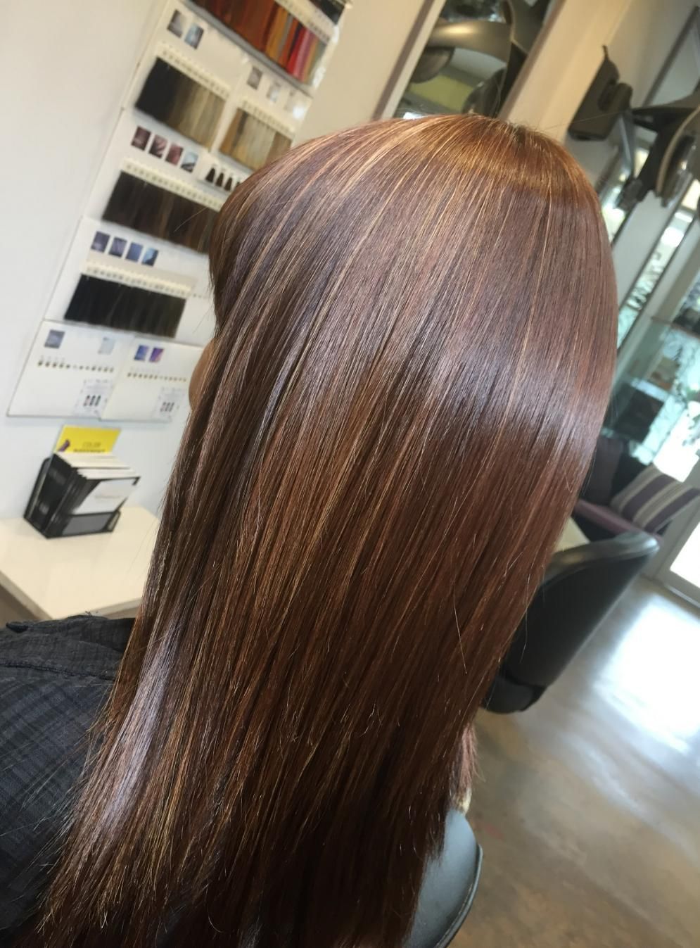 A Woman With Long Brown Hair Is Sitting In A Chair In A Salon — Fuse Hair & Beauty In Darwin City, NT