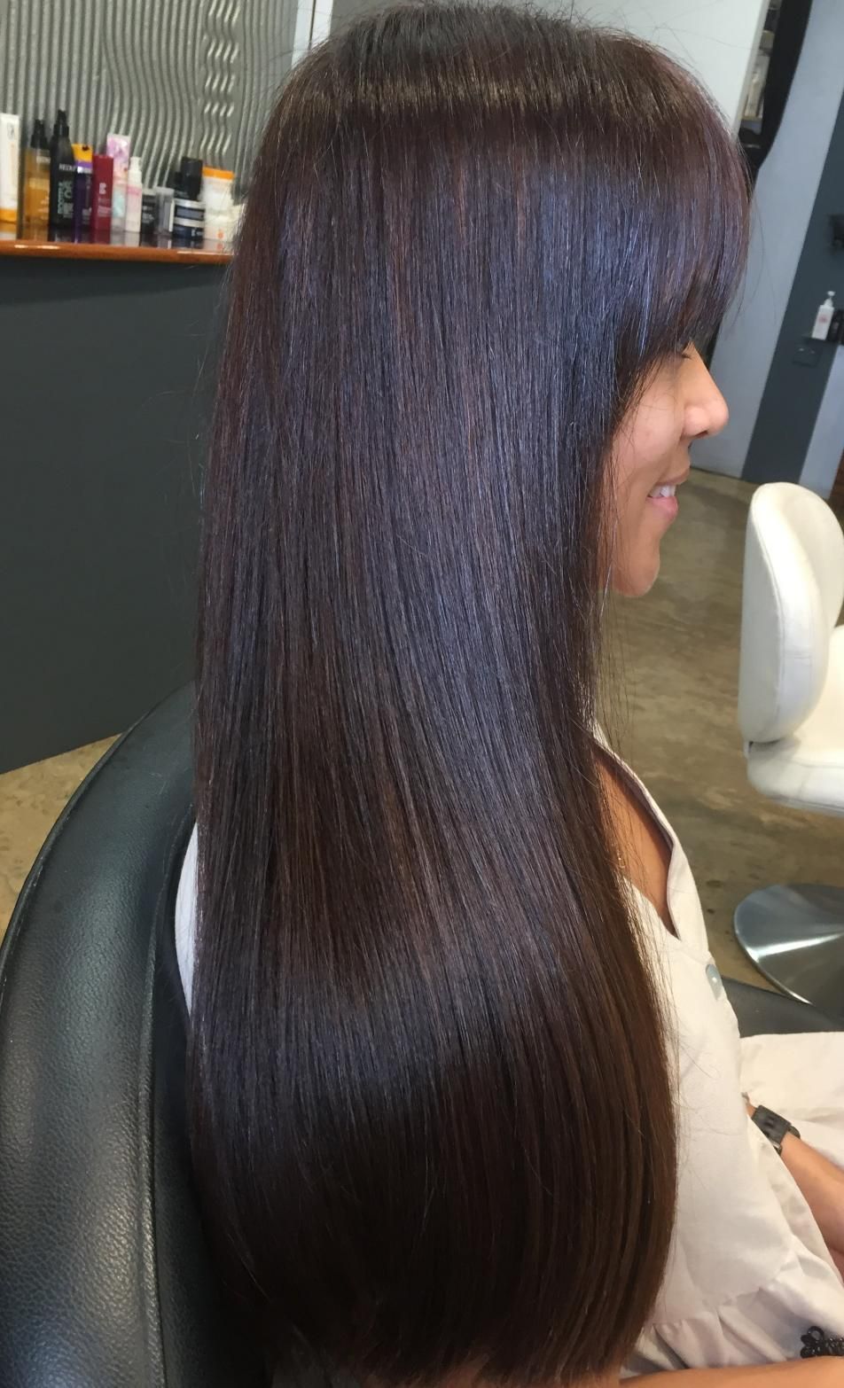 A Woman With Long Hair Is Sitting In A Chair In A Salon — Fuse Hair & Beauty In Darwin City, NT