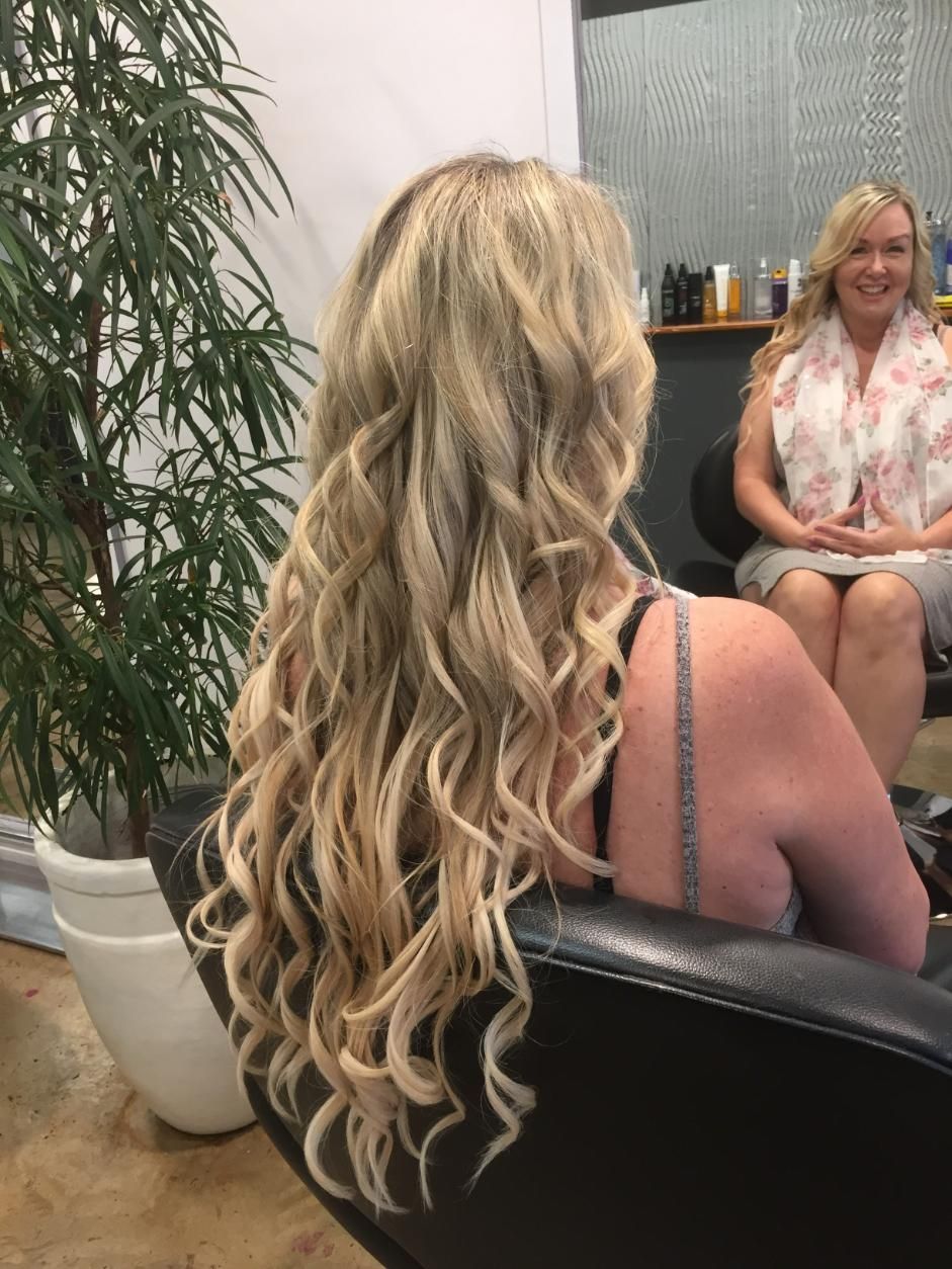 A Woman With Long Blonde Hair Is Sitting In A Chair In Front Of A Mirror — Fuse Hair & Beauty In Darwin City, NT