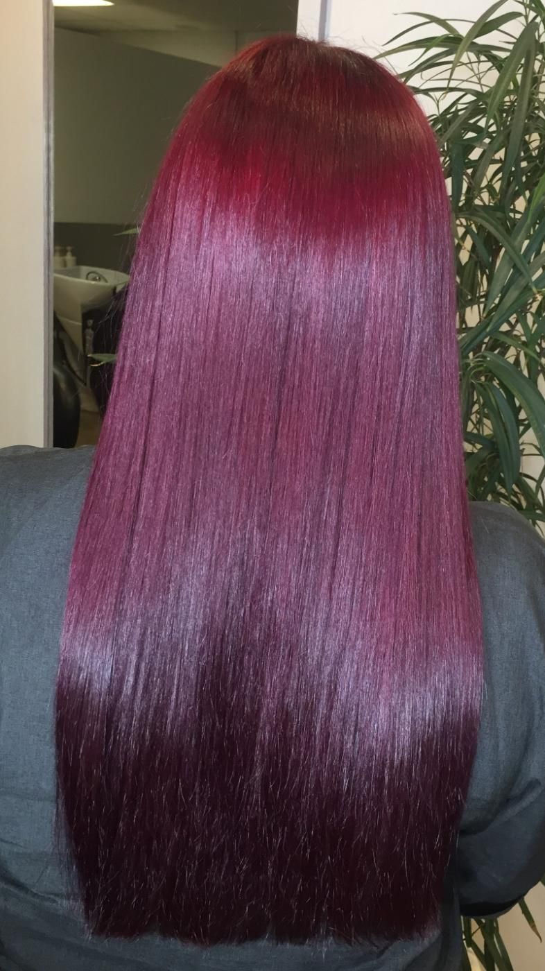 A Woman With Long Red Hair Is Standing In Front Of A Mirror — Fuse Hair & Beauty In Darwin City, NT