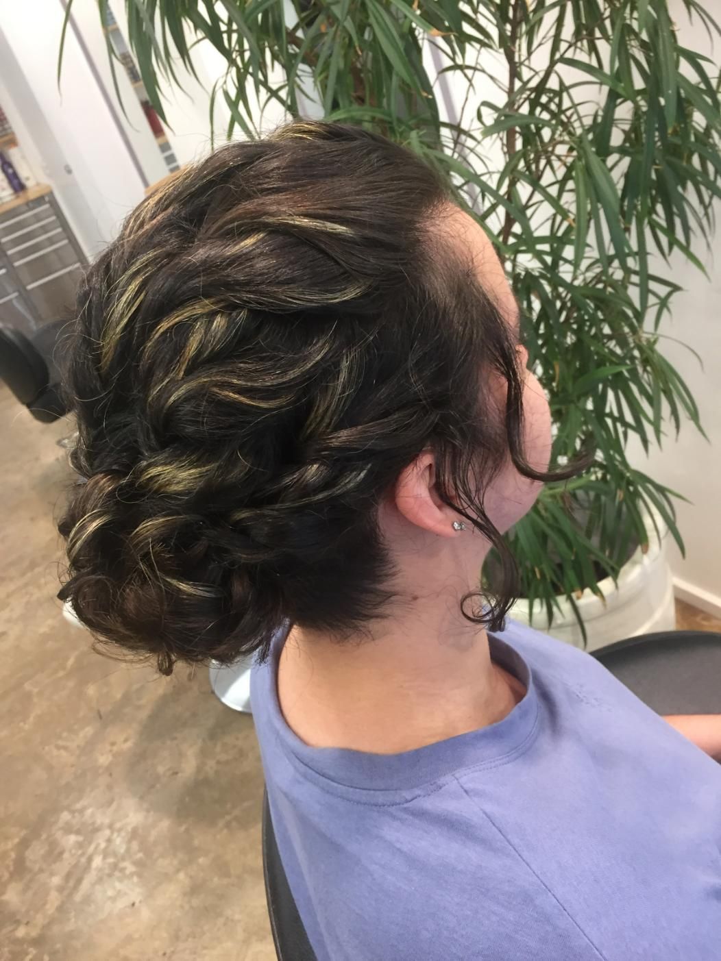A Woman Is Sitting In A Chair With Her Hair In A Bun — Fuse Hair & Beauty In Darwin City, NT