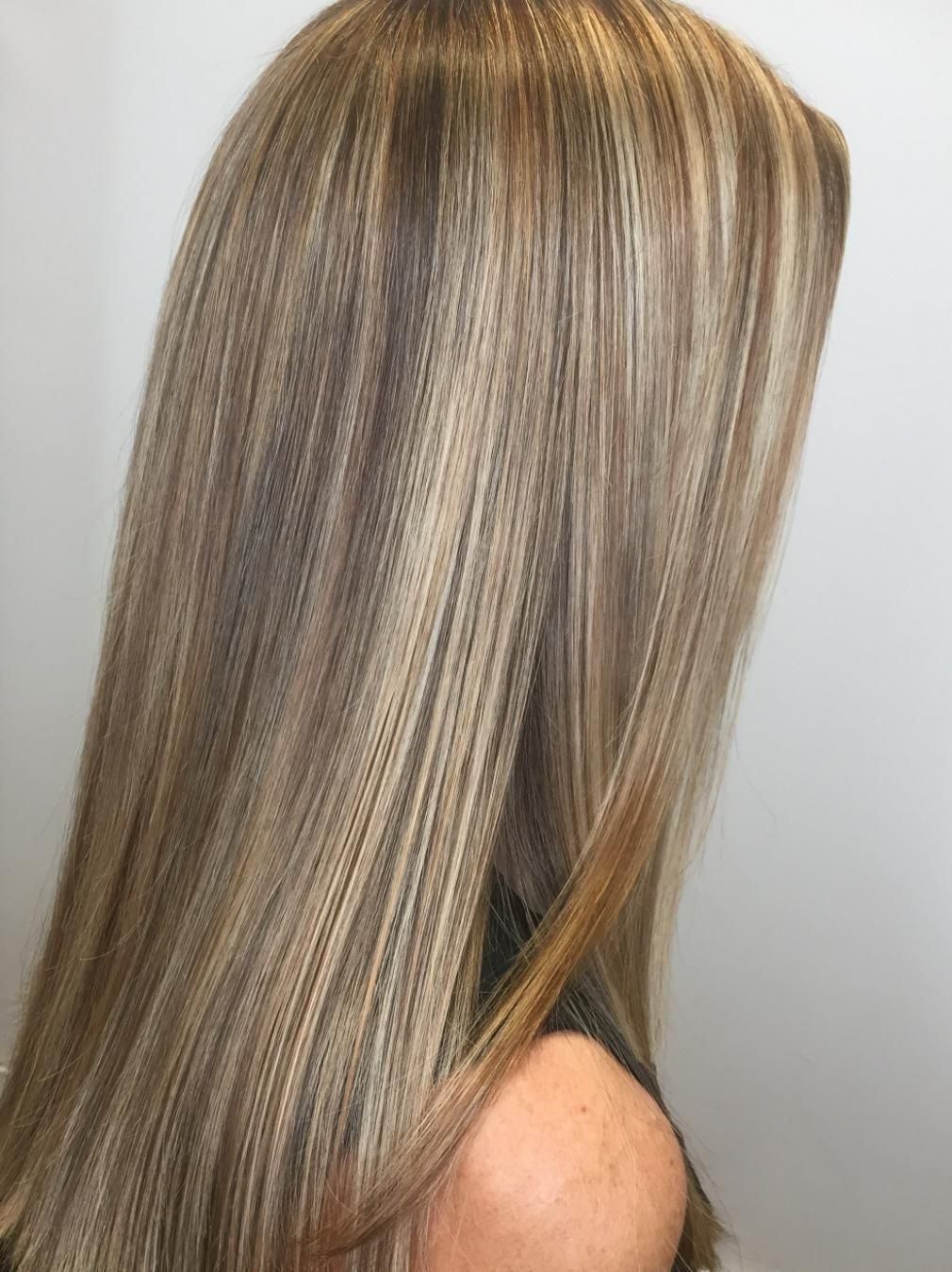 A Woman With Long Blonde Hair Is Covering Her Face With Her Hair — Fuse Hair & Beauty In Darwin City, NT