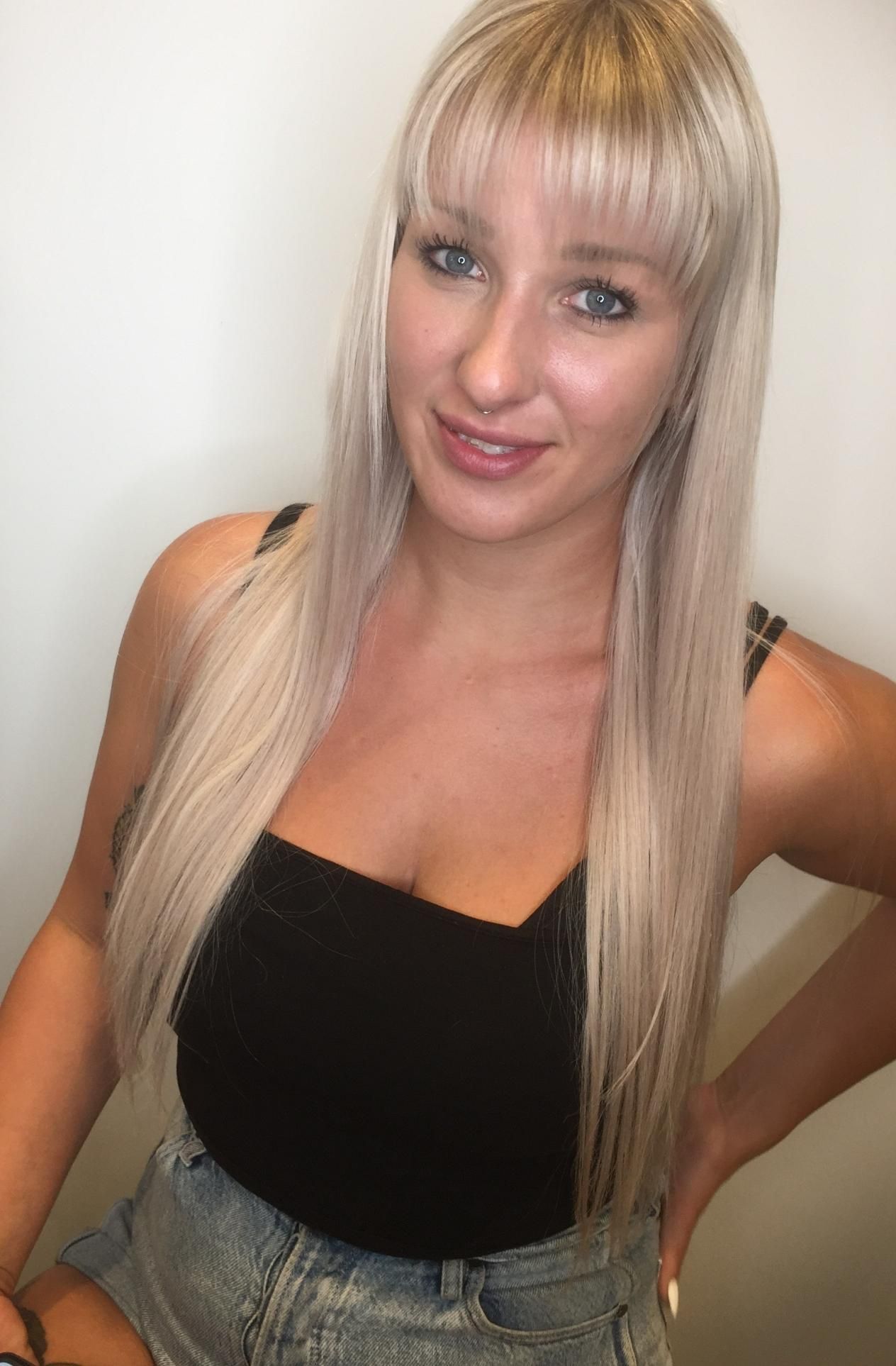 A Woman With Long Blonde Hair Is Wearing A Black Top And Shorts — Fuse Hair & Beauty In Darwin City, NT