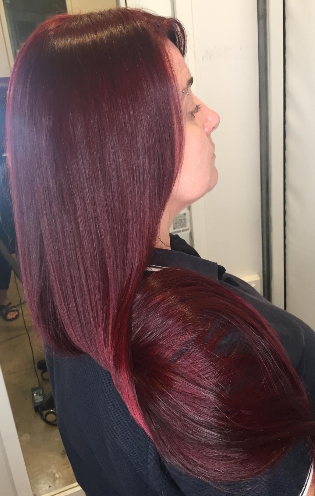 A Woman With Long Red Hair Is Sitting In Front Of A Mirror — Fuse Hair & Beauty In Darwin City, NT