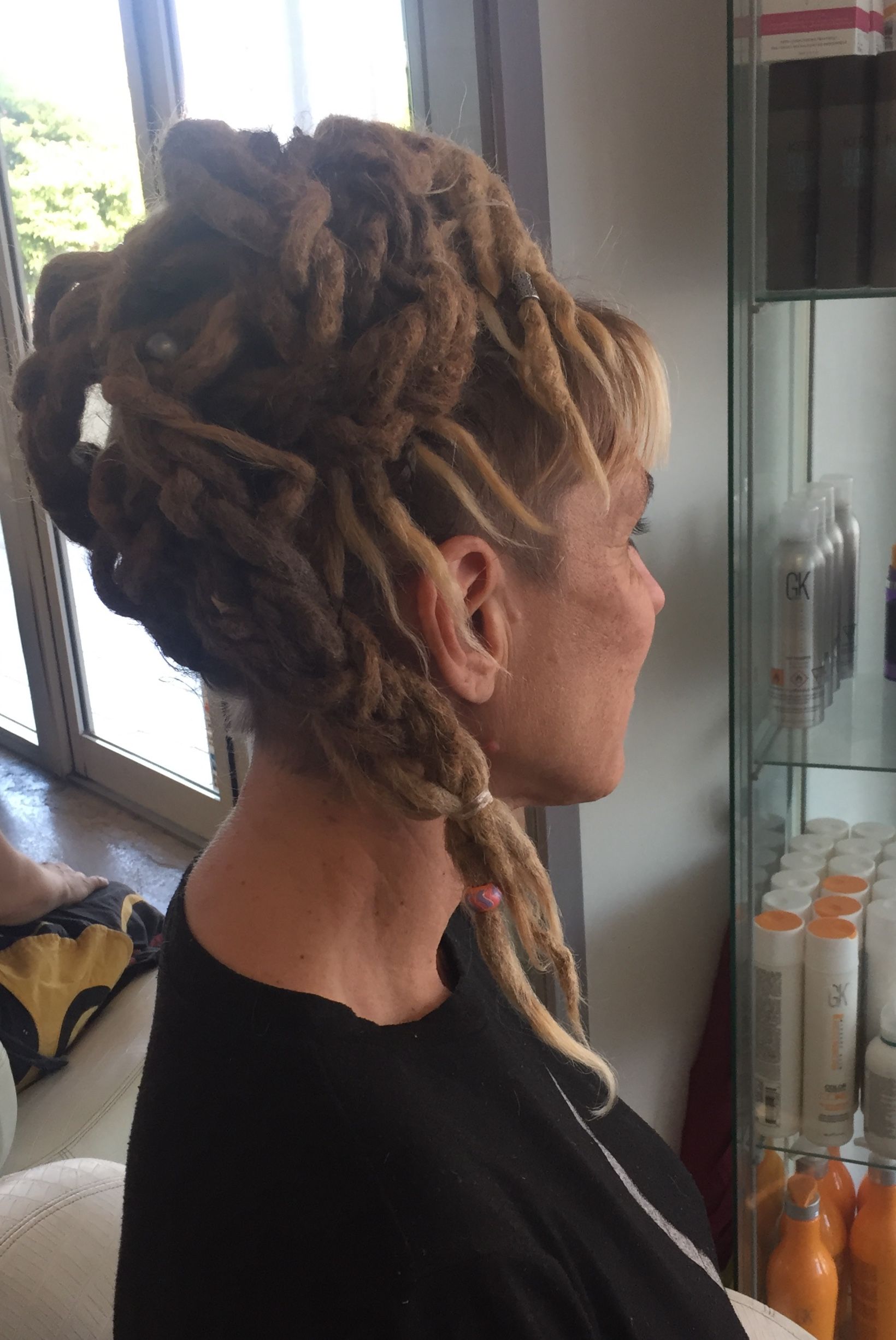 A Woman With Dreadlocks Is Sitting In A Chair In A Salon — Fuse Hair & Beauty In Darwin City, NT