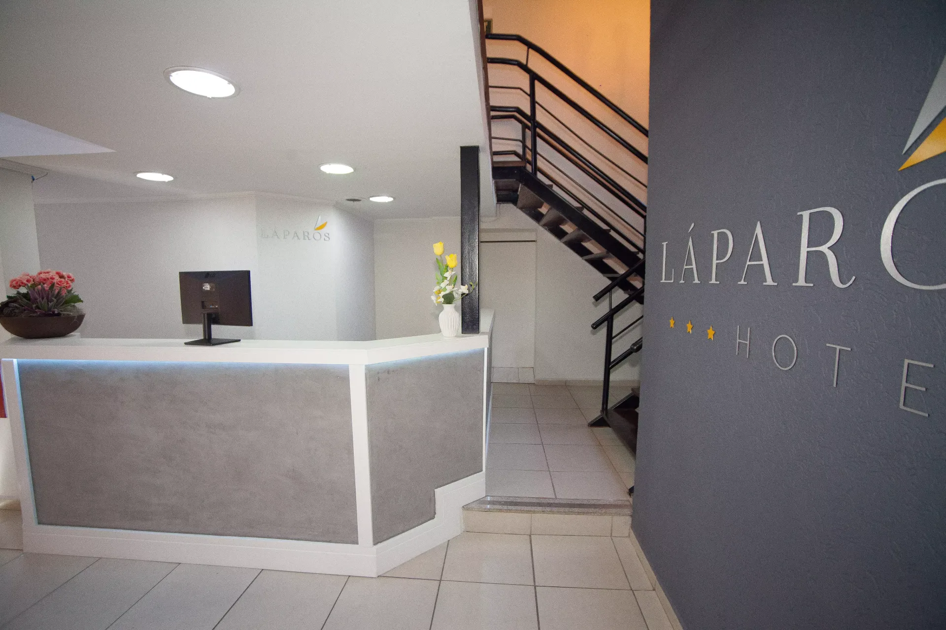 Uma imagem borrada de um saguão de hotel com escadas e uma mesa -Láparos hotel