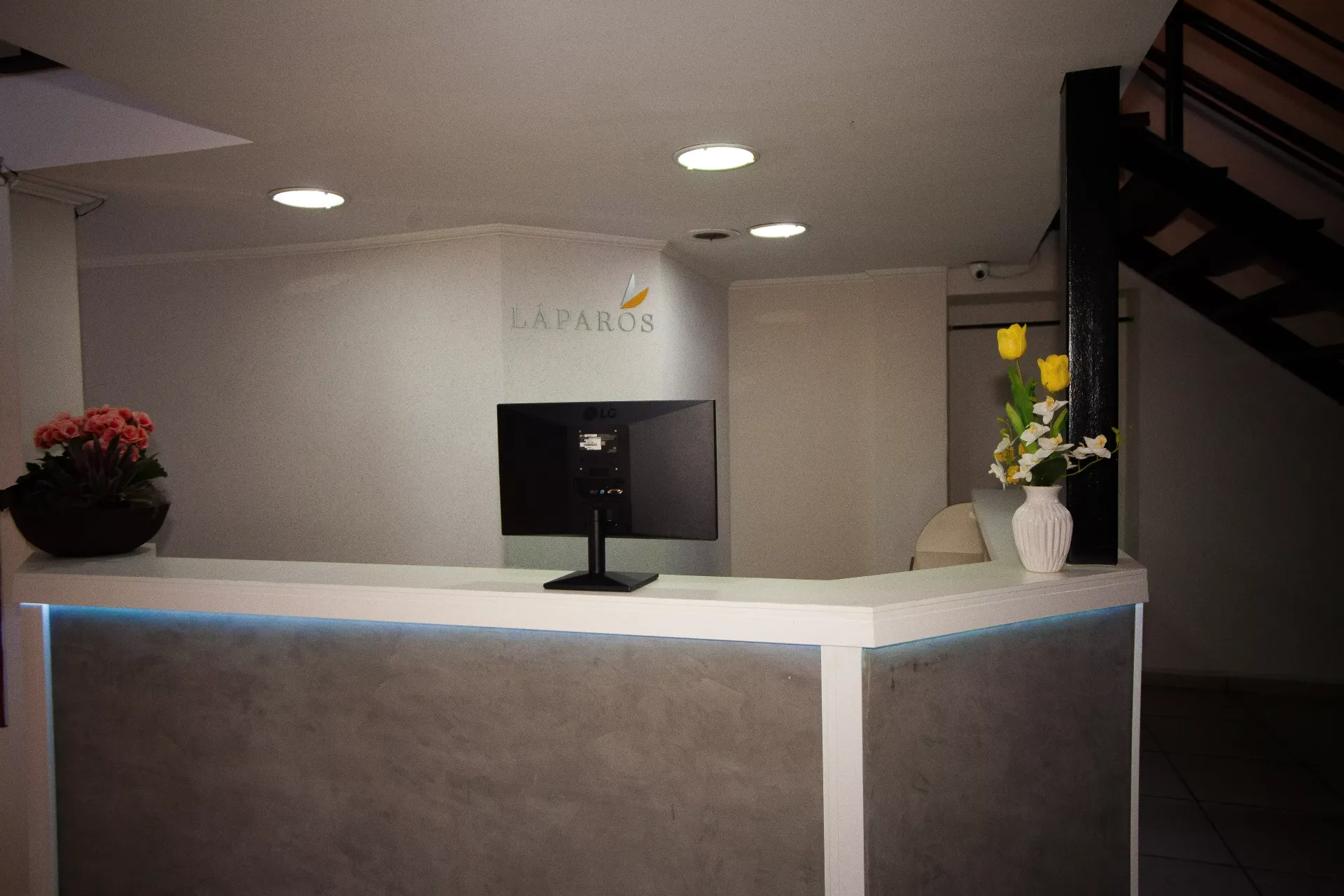 Uma recepção com um computador em uma sala escura - Láparos hotel