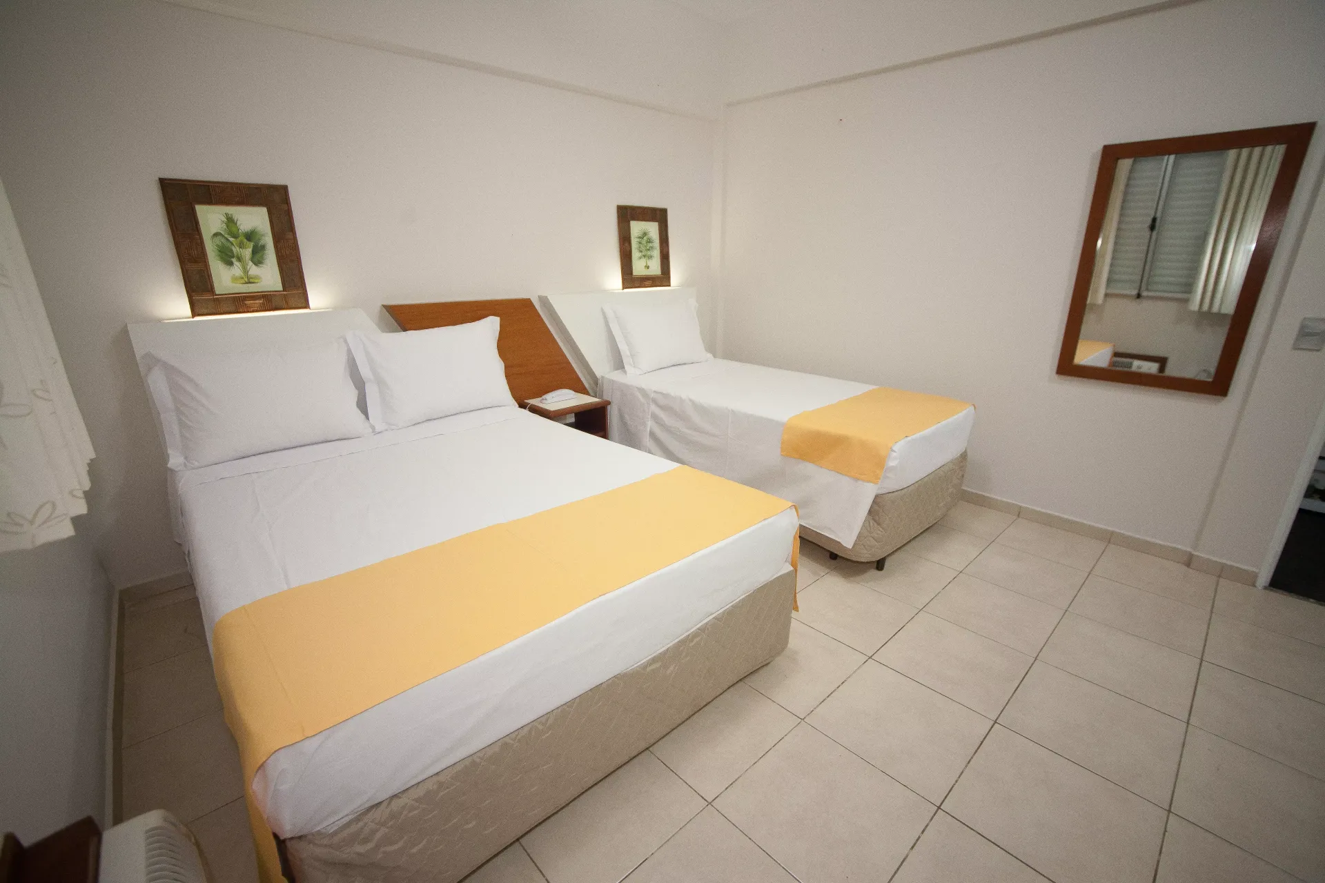 Um quarto de hotel com duas camas e um espelho - Láparos hotel