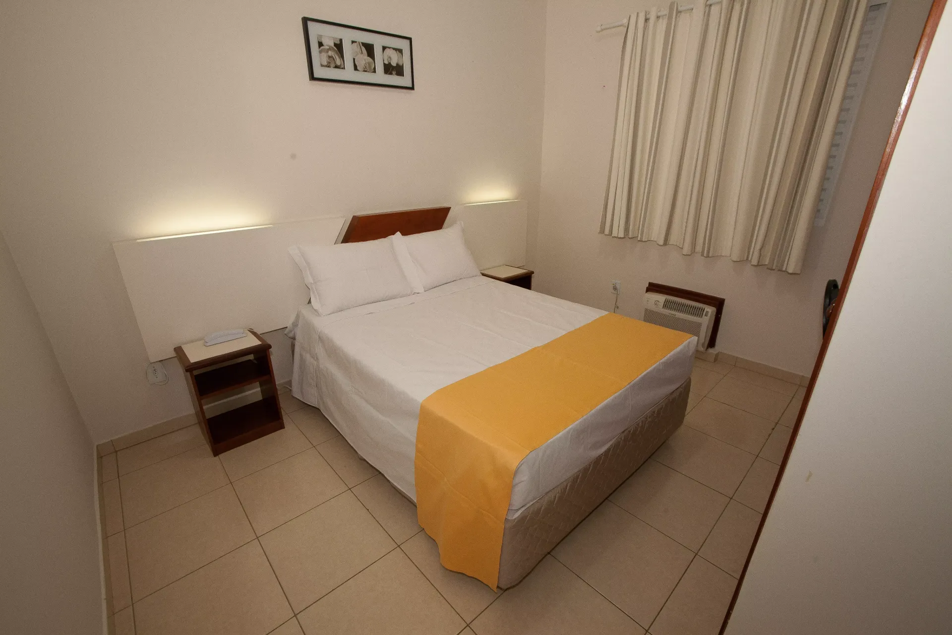 Um quarto de hotel com uma cama e duas mesas de cabeceira - Láparos hotel