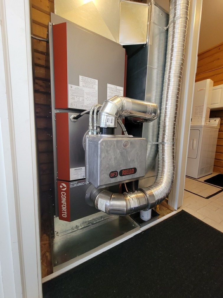 A room with a heater and a hose coming out of it.
