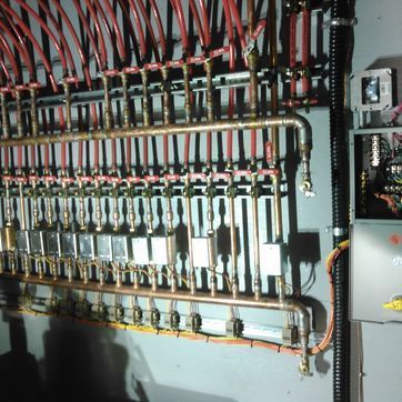 A bunch of wires and pipes hanging on a wall