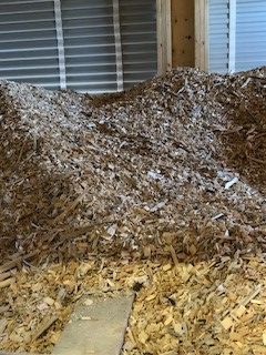 A pile of wood chips is sitting on the floor in a room.