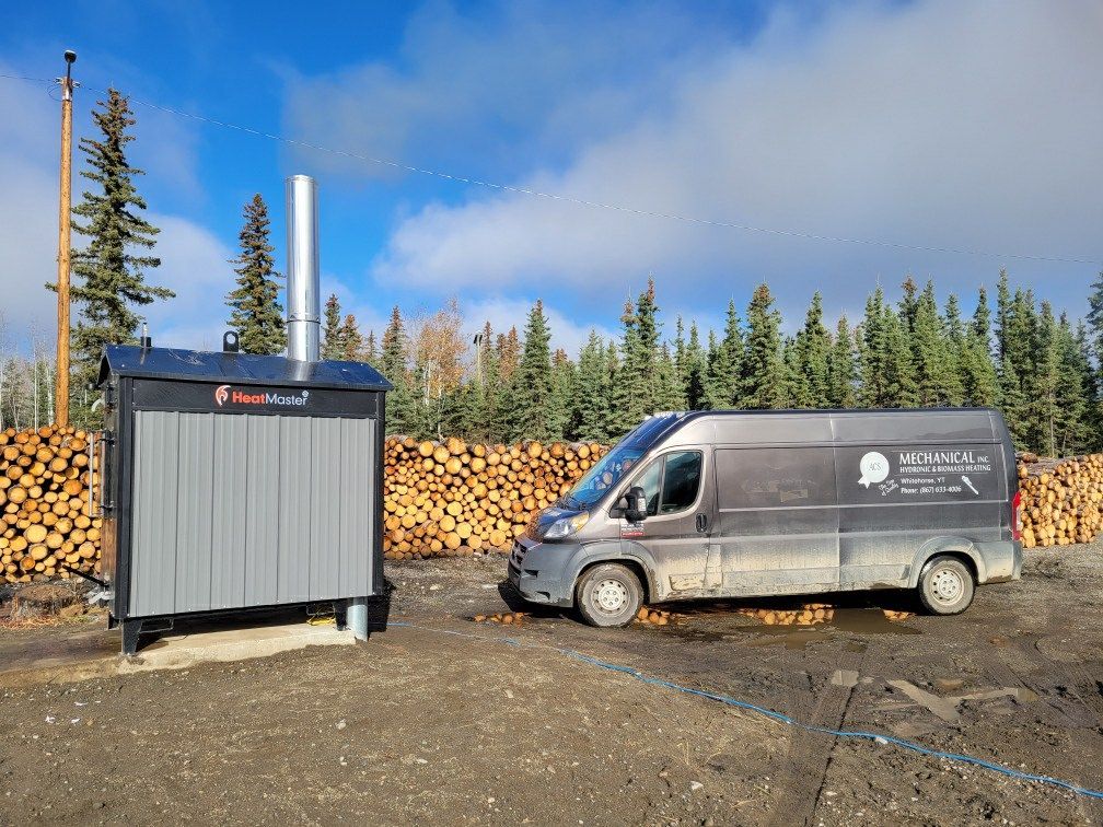 A van is parked in front of a pile of logs.