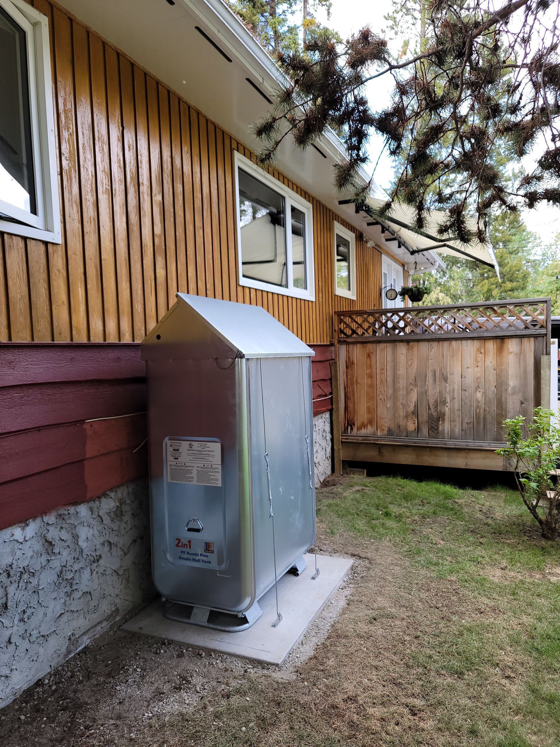 A large metal box is sitting on the side of a house.